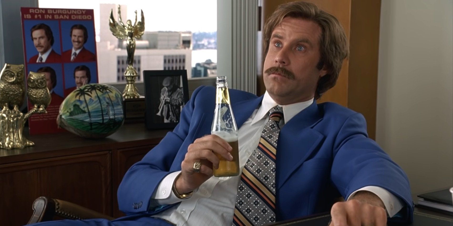 Ron Burgundy przy biurku pije alkohol po wielkiej bitwie ze stacją informacyjną 