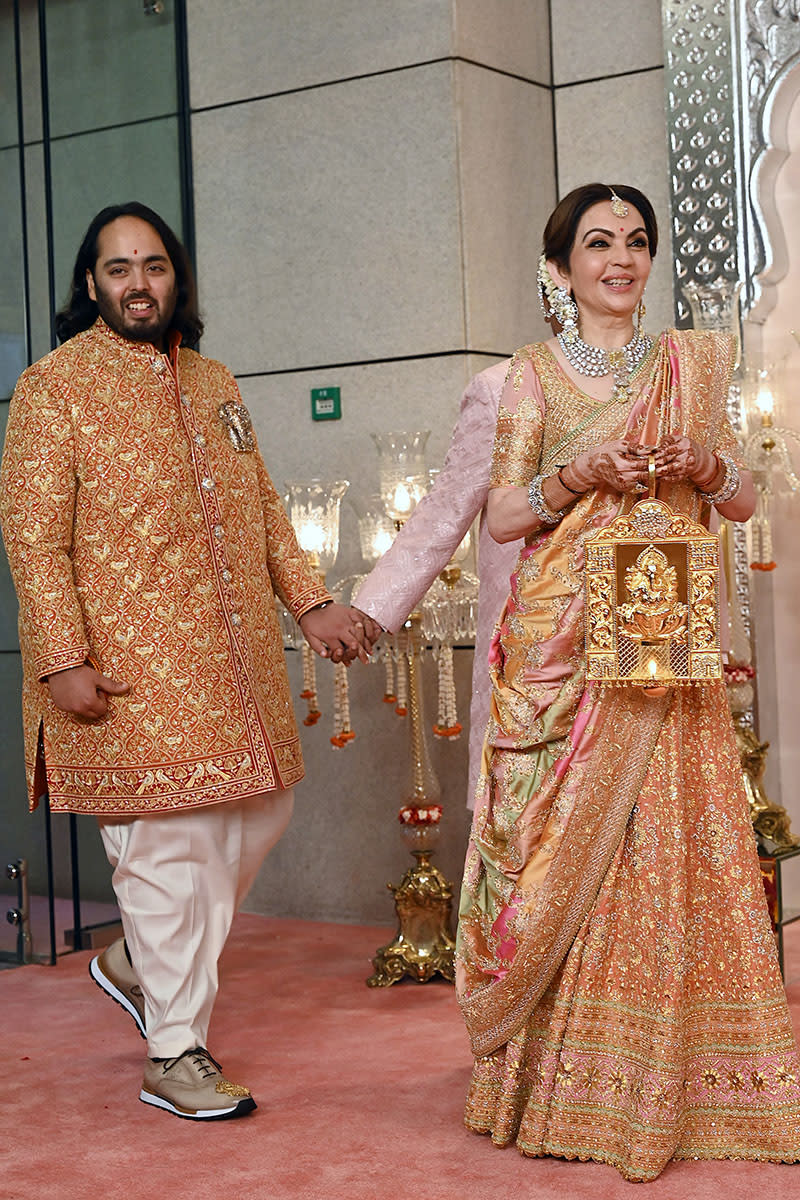 Anant Ambani (po lewej), syn miliardera i prezesa Reliance Industries Mukesha Ambaniego, oraz jego matka Nita Ambani (po prawej) przybywają na ceremonię zaślubin w Mumbaju 12 lipca 2024 r. Siostry Kim i Khloe Kardashian, celebrytki z wyższych sfer, znalazły się wśród światowych celebrytów zauważonych w Indiach 12 lipca na wystawnej, trzydniowej ceremonii ślubnej zorganizowanej przez najbogatszego mężczyznę Azji, Mukesha Ambaniego. (Zdjęcie: SUJIT JAISWAL / AFP) (Zdjęcie: SUJIT JAISWAL/AFP via Getty Images)