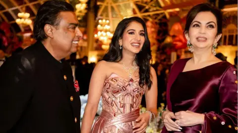 Reuters Mukesh Ambani, prezes Reliance Industries, Radhika Merchant i Nita Ambani dzielą się chwilą podczas uroczystości przedślubnych