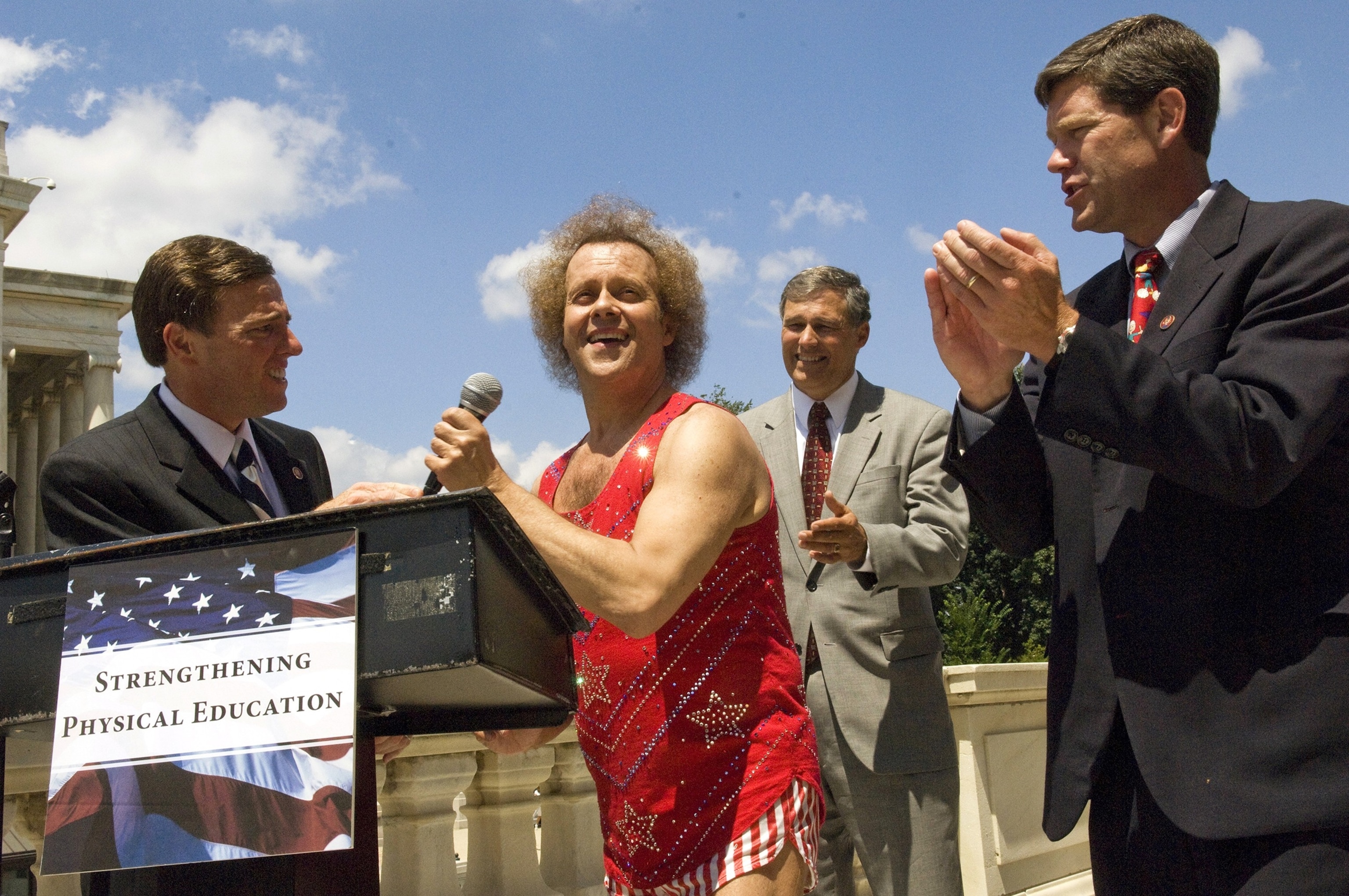 ZDJĘCIE: Zwolennik fitnessu Richard Simmons bierze mikrofon podczas wiecu w Kapitolu Stanów Zjednoczonych, 24 lipca 2008 r., w Waszyngtonie, D.C.