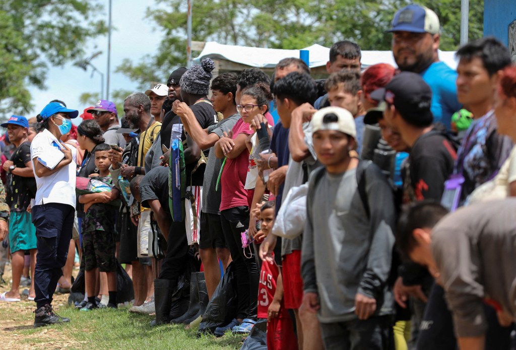 Migranci ustawiają się w kolejce na badania lekarskie w punkcie przyjmowania migrantów podczas wizyty wybranego prezydenta Panamy Jose Raula Mulino (niewidocznego na zdjęciu) w Lajas Blancas w prowincji Darien w Panamie, 28 czerwca 2024 r. 