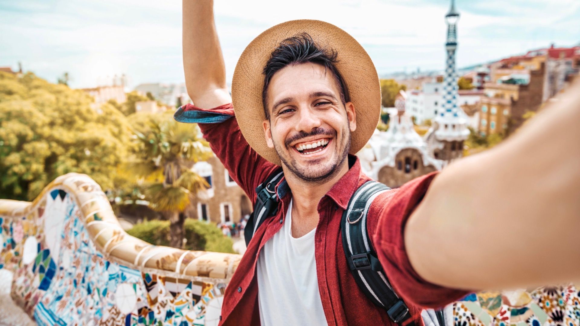 Szczęśliwy turysta robi sobie selfie smartfonem w Parku Guell w Barcelonie w Hiszpanii