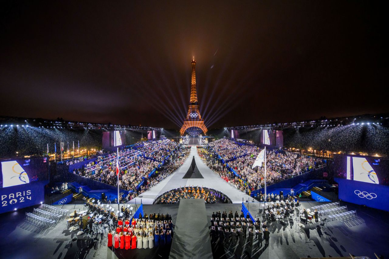 W tle widać wieżę Eiffla, a flaga olimpijska zostaje podniesiona podczas ceremonii otwarcia Igrzysk Olimpijskich w Paryżu, 26 lipca. 