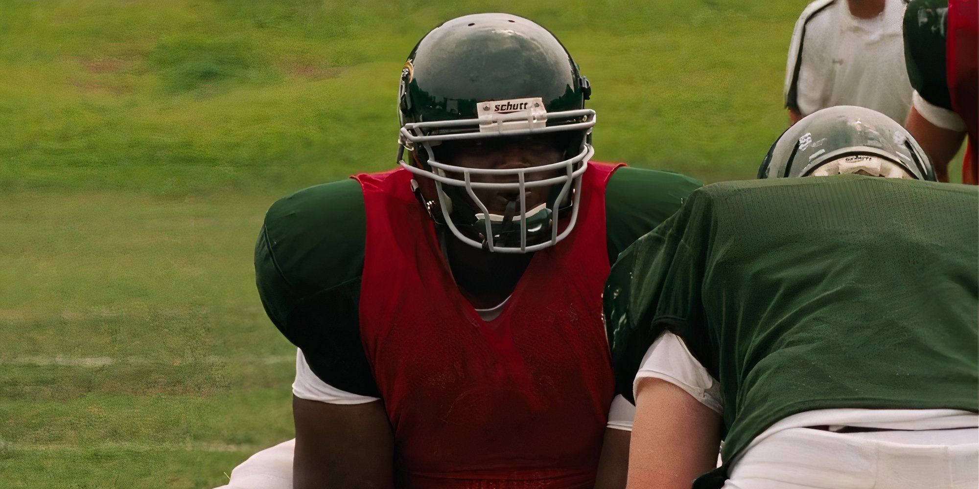 Quinton Aaron jako Michael Oher grający w piłkę nożną w filmie The Blind Side