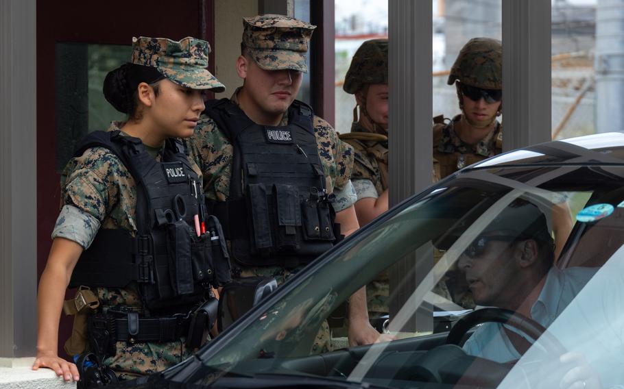 Marine Lance Cpls. Alize Reyes, po lewej, i Austin Walker sprawdzają dowody osobiste w Marine Corps Air Station Futenma, Okinawa, Japonia, 27 marca 2024 r. Kontrole trzeźwości zaplanowano we wszystkich bazach Marines w Japonii na 12 i 13 lipca 2024 r.