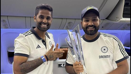 Kapitan reprezentacji Indii Rohit Sharma i Suryakumar Yadav pozują z trofeum Pucharu Świata ICC T20 na pokładzie samolotu odlatującego do Indii z Bridgetown na Barbadosie. (PTI)