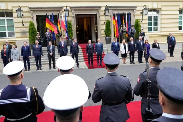 Kanclerz Niemiec Olaf Scholz (środek po lewej) i premier Polski Donald Tusk (środek po prawej) przeglądają wartę honorową w Warszawie