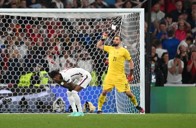 ZDJĘCIE Z ARCHIWUM: Piłka nożna Piłka nożna - Euro 2020 - Finał - Włochy kontra Anglia - Stadion Wembley, Londyn, Wielka Brytania - 11 lipca 2021 r. Marcus Rashford z Anglii nie wykorzystuje rzutu karnego podczas serii rzutów karnych, podczas gdy Gianluigi Donnarumma z Włoch świętuje Pool za pośrednictwem REUTERS/Andy Rain/Zdjęcie z archiwum