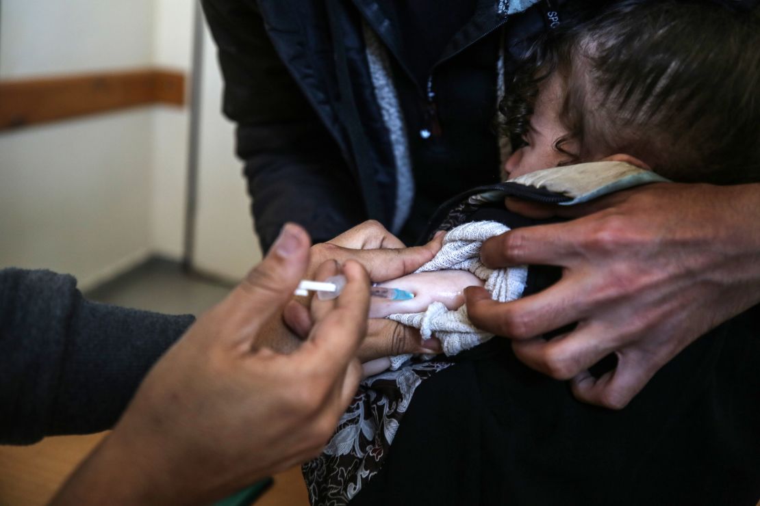 Pracownik UNRWA podaje szczepionkę przeciwko polio w klinice w Deir al-Balah, w centralnej części Strefy Gazy, 21 stycznia 2024 r.