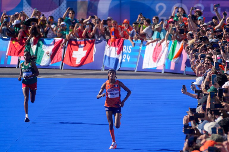 Sifan Hassan z Holandii, po prawej, i Tigst Assefa z Etiopii, po lewej, zbliżają się do linii mety kobiecego maratonu na Letnich Igrzyskach Olimpijskich 2024, w niedzielę 11 sierpnia 2024 r. w Paryżu we Francji. (AP Photo/Dar Yasin)