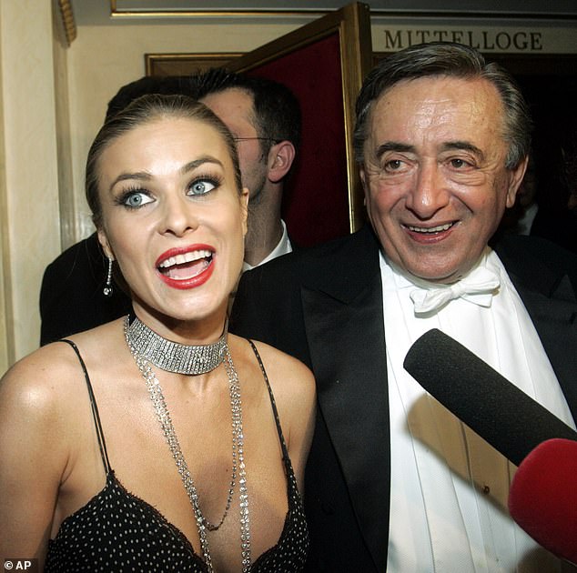 Amerykańska aktorka Carmen Electra rozmawia z reporterami, a jej gospodarz, austriacki biznesmen Richard Lugner, słucha podczas tradycyjnego Balu Operowego, w czwartek 23 lutego 2006 r.