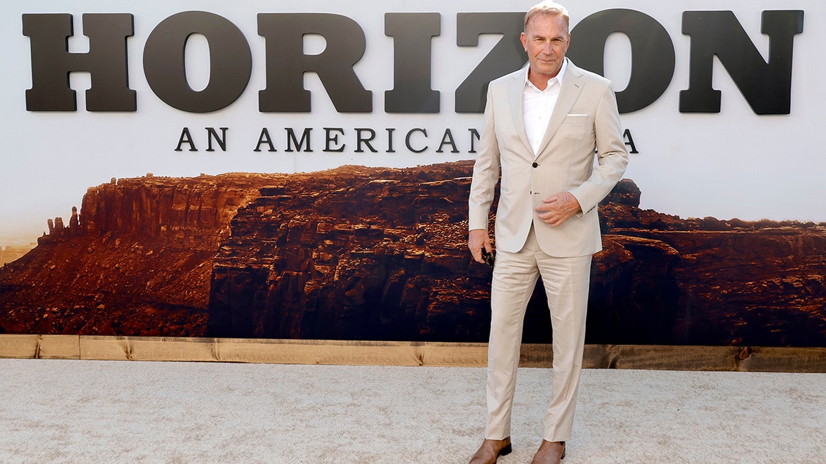 Kevin Costner pozował do zdjęć na amerykańskiej premierze filmu „Człowiek z krwi i kości” w brązowym garniturze i brązowych mokasynach. "Horizon: An American Saga - Rozdział 1."