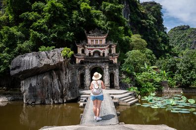 Selektywne skupienie. Turysta spacerujący wokół Bich Dong Pagoda, Ninh Binh, Wietnam. Niesamowita wietnamska pagoda. Piękna wietnamska świątynia w jaskini. Piękna Bich Dong Pagoda