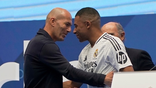 Francuz Kylian Mbappe obejmuje francuską legendę Zinedine’a Zidane’a (po lewej) podczas prezentacji kibicom jako nowego piłkarza Realu Madryt na stadionie Santiago Bernabeu (AP)