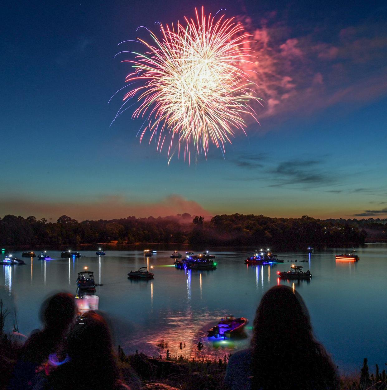 Ludzie wzdłuż wału nad jeziorem Hartwell oglądają pokaz sztucznych ogni Clemson Light the Lake w Clemson w Karolinie Południowej w środę 3 lipca 2024 r.