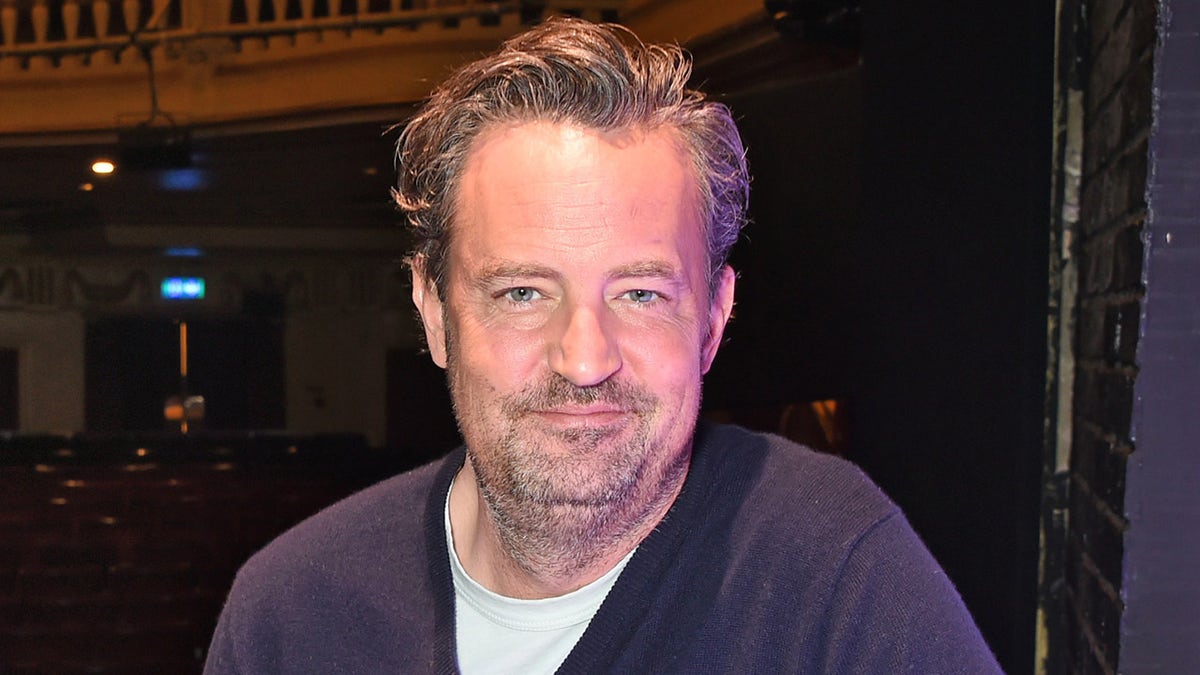 Matthew Perry na wydarzeniu ma na sobie niebieski sweter i koszulkę