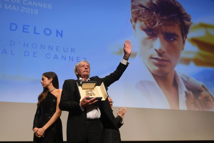 Na zdjęciu z niedzieli 19 maja 2019 r. aktor Alain Delon (w środku) trzyma honorową Złotą Palmę na 72. Międzynarodowym Festiwalu Filmowym w Cannes w południowej Francji. (Zdjęcie: Arthur Mola/Invision/AP)