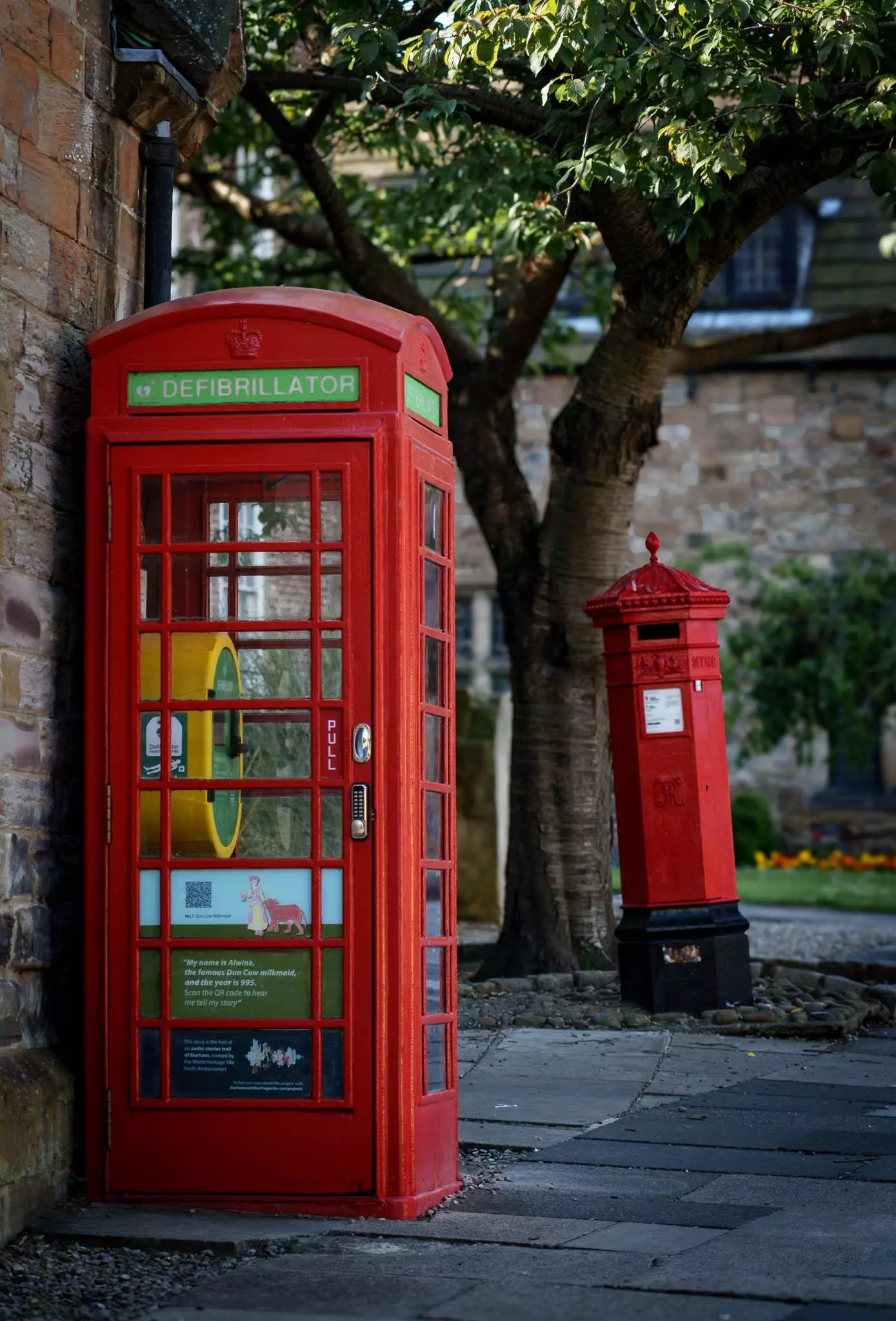 Stara brytyjska czerwona budka telefoniczna z czerwoną skrzynką pocztową z tyłu w Durham, UK. Nagrane na Sony a7Rv