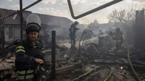 REUTERS/Thomas Peter Pracownicy służb ratunkowych gaszą pożar, który zniszczył prywatny dom po rosyjskim ataku na osiedle mieszkaniowe w Pokrovsk w trakcie ataku Rosji na Ukrainę, 3 sierpnia 2024 r.