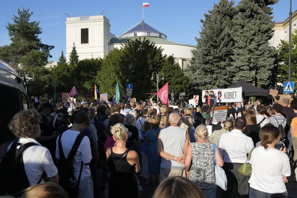 PLIK - Kilkaset osób protestuje przeciwko niedawnemu niepowodzeniu centrowego rządu premiera Donalda Tuska w uzyskaniu wystarczającego poparcia dla głosowania nad liberalizacją surowego prawa antyaborcyjnego w kraju przed budynkiem parlamentu w Warszawie, 23 lipca 2024 r. (AP Photo/Czarek Sokolowski, File)