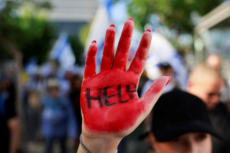 Osoba podnosi rękę, gdy rodziny izraelskich zakładników przetrzymywanych w Strefie Gazy od 7 października wyruszają na marsz protestacyjny z Tel Awiwu do Jerozolimy, próbując wywrzeć presję na rząd Izraela, aby zawarł porozumienie, które uwolni ich bliskich, pośród konfliktu Izraela z Hamasem, w Tel Awiwie, Izrael, 10 lipca 2024 r. REUTERS/Ammar Awad