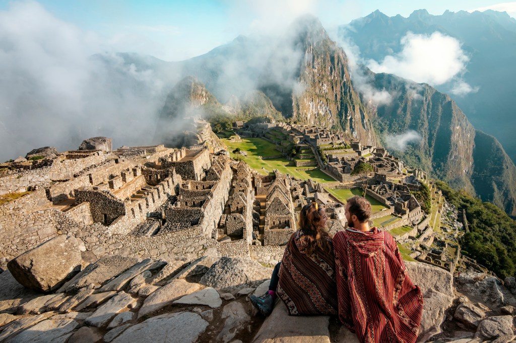 Para ubrana w poncza ogląda ruiny Machu Picchu