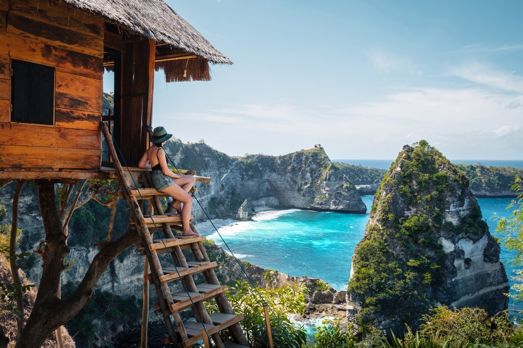 Bali, Indonezja, podróżnik w domku na drzewie przy Diamond Beach na wyspie Nusa Penida.