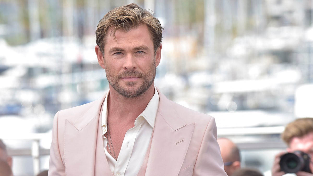 Chris Hemsworth w brązowym garniturze