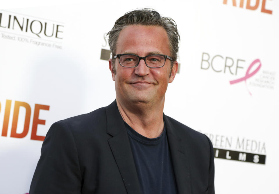 Matthew Perry uśmiecha się na konferencji prasowej.