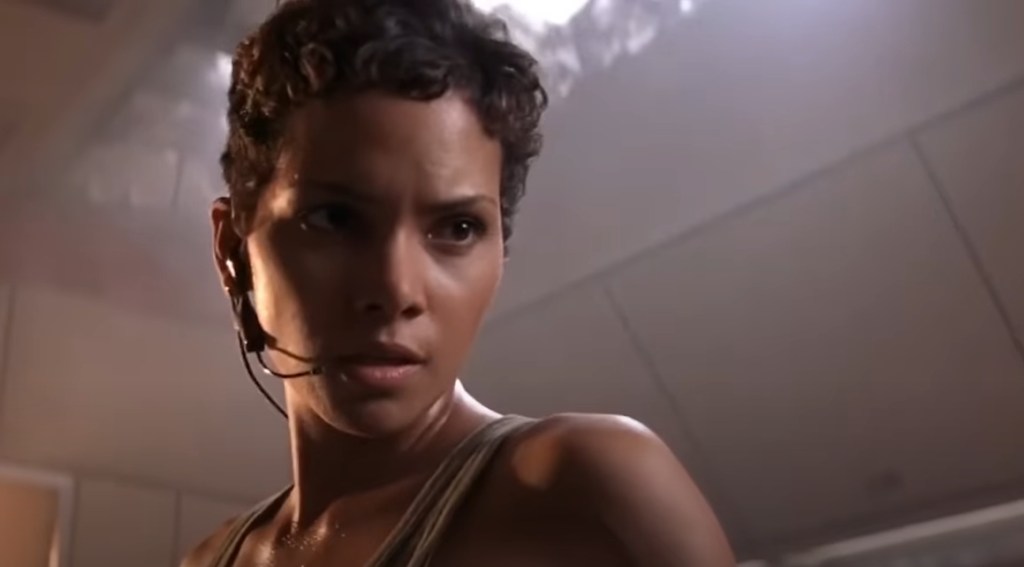 Jinx (Halle Berry) uczy, jak ważne jest czytanie w filmie UMRZEĆ JESZCZE DZIEŃ (2002), MGM