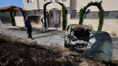 Getty Images Ludzie oceniają szkody dzień po ataku osadników żydowskich na wioskę Jit w pobliżu Nablusu na okupowanym Zachodnim Brzegu