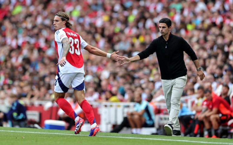 LONDYN, ANGLIA - 11 SIERPNIA: Riccardo Calafiori z Arsenalu dotyka dłoni menedżera Arsenalu Mikela Artety podczas towarzyskiego meczu przedsezonowego pomiędzy Arsenalem i Olympique Lyon na Emirates Stadium 11 sierpnia 2024 r. w Londynie, Anglia. (Zdjęcie: David Rogers/Getty Images)