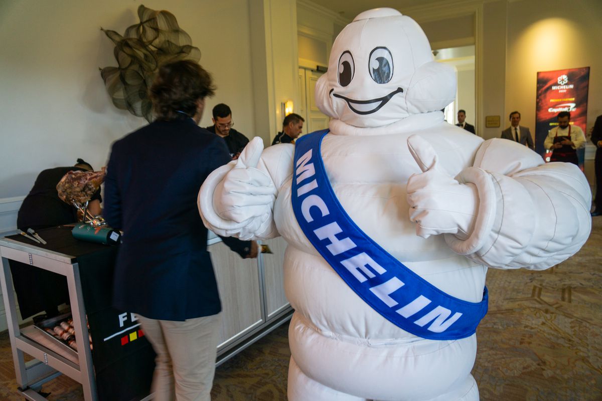 Widok poziomy maskotki Michelin Man w sali bankietowej hotelu.