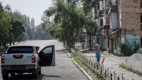 Getty Images Ukraińska policjantka przekonuje miejscową mieszkankę, która odmawia ewakuacji, do zmiany zdania i opuszczenia Torecka