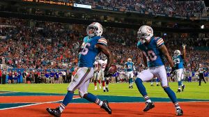 MIAMI GARDENS, FL - 14 GRUDNIA: Lamar Miller #26 z Miami Dolphins zdobywa przyłożenie w pierwszej kwarcie meczu przeciwko New York Giants na Sun Life Stadium 14 grudnia 2015 r. w Miami Gardens na Florydzie. (Zdjęcie: Chris Trotman/Getty Images)